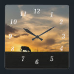 Cattle Sunset Silhouette Wall Clock<br><div class="desc">Wall Clock - A cow eats in front of a beautiful country sunset. This silhouette capture was taken in Ozark, Missouri. Looking for more prints or products? Feel free to visit my store: http://www.zazzle.com/timelessmomentsphtgy This photo was taken by Jennifer White with Timeless Moments Photography. All images are copyrighted © Timeless...</div>