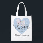 Celebrating Love Romantic Blue Heart Bridesmaid Reusable Grocery Bag<br><div class="desc">Traditional romantic design. A pretty blue heart pattern with a lacy white bow on top. Celebrating Love is written across the heart and bow. Then the bride and groom first names with the date of the wedding. The bridesmaid title is written below. All of the text can be easily changed....</div>