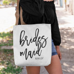 Chic Script Personalized Bridesmaid Tote Bag<br><div class="desc">Gift your bridesmaids with these super cute personalized tote bags! Trendy and modern black and white design features "bridesmaid in black handwritten script typography. Easily customize with your bridesmaid's name using the template field provided.</div>