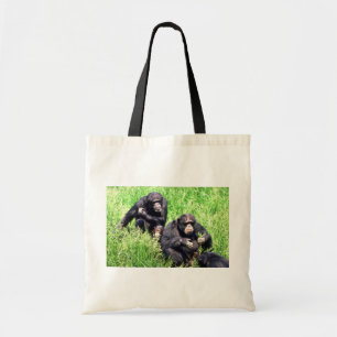 Chimpanzees eating grass (note infant) tote bag