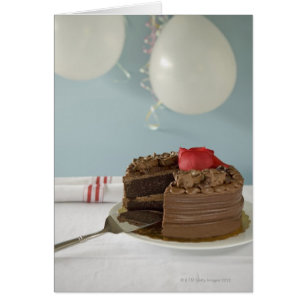Chocolate cake with missing slice on table,