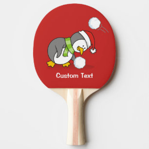Christmas penguin getting a snow ball ping pong paddle