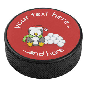 Christmas penguin sitting with snow balls hockey puck