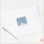 Christmas Snowman In Snowflakes Square Sticker<br><div class="desc">Cute snowman with a blue stocking cap in snowflakes on a blue background with Merry Christmas text.</div>