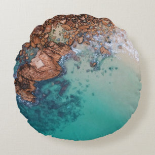 Clear blue sea and rocks round cushion