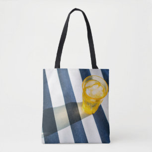 Clear drinking glass with yellow liquid tote bag