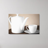 Close-up of a cup and a saucer with a tea kettle