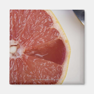 Close-up of a slice of orange and a spoon magnet