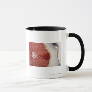 Close-up of a slice of orange and a spoon mug