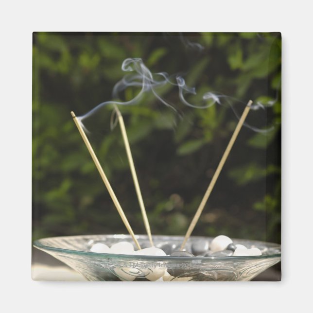 Close-up of burning incense sticks with pebbles magnet (Front)