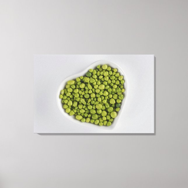 Close-up of green pebbles in a heart shape bowl canvas print (Front)