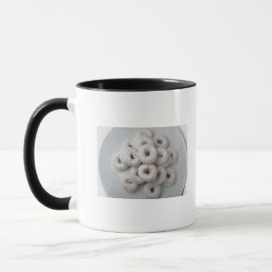 Close-up of powdered doughnuts in a plate mug