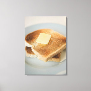 Close up of toasts with butter on plate canvas print