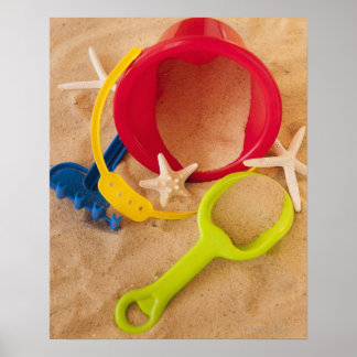 Close up of toys on sand poster