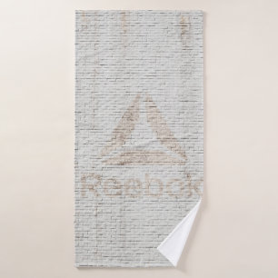 Close-up photo of Reebok logo on wall Bath Towel