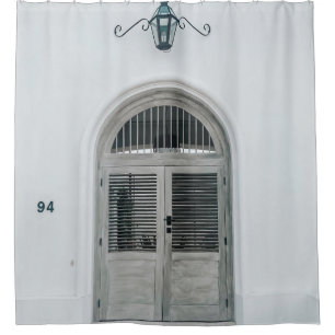 CLOSED GREY WOODEN DOOR BELOW BLACK LIGHT SCONCE SHOWER CURTAIN