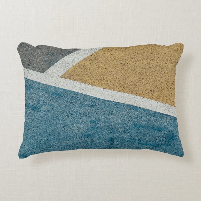 Closeup grey, yellow, and blue painted pavement decorative cushion (Front)