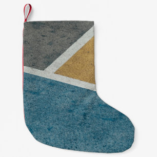 Closeup grey, yellow, and blue painted pavement small christmas stocking