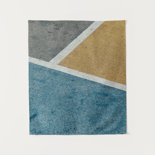 Closeup grey, yellow, and blue painted pavement tapestry (Front)
