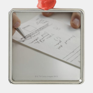 Closeup of hands signing prescription metal tree decoration