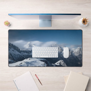 Clouds rolling above snowy mountains desk mat