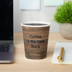 Coffee is the new black over a woody background paper cups