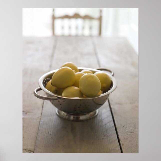 Colander with lemons on wooden table poster (Front)