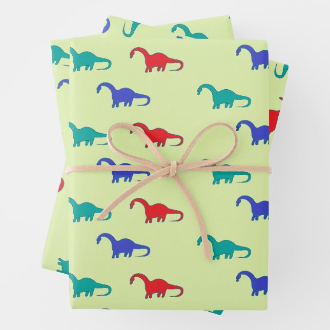 Colourful dinosaurs pattern on green wrapping paper sheet (In situ)