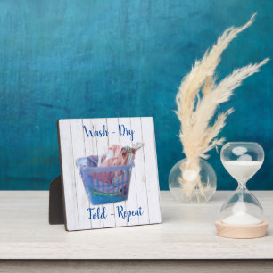 Colourful Folded Laundry On Hangers In Blue Basket Plaque