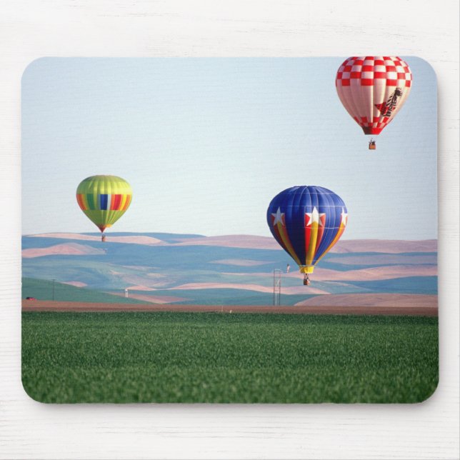 Colourful hot air balloons float over wheat mouse pad (Front)