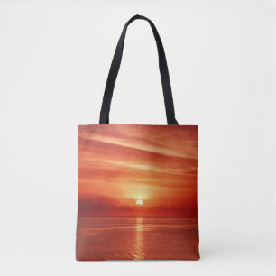 Colourful sunrise at sea, dramatic clouds. tote bag