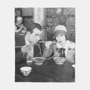 Couple sharing a noodle in a restaurantvintage, fo fleece blanket
