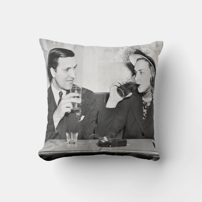 Couple sitting together in a restaurant flirting w cushion (Front)