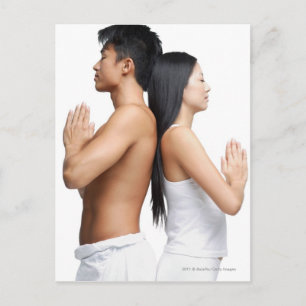 Couple standing back to back in yoga position postcard