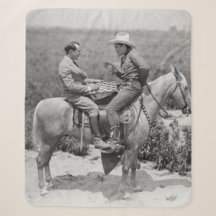 Cowboy and businessman playing checkers on horseba sherpa blanket