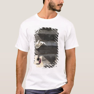 Cowboy hat on guitar leaning on log cabin T-Shirt