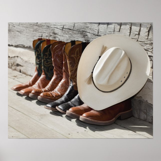 Cowboy hat on row of cowboy boots outside a log poster (Front)