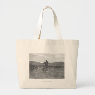 Cowboy roping a calf for spring branding. large tote bag