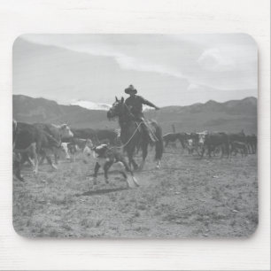 Cowboy roping a calf for spring branding. mouse pad