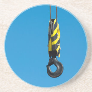 Crane hook with yellow and black stripes hanging coaster
