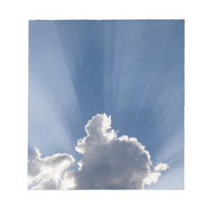 Crepuscular or God's rays streak past cloud. Notepad