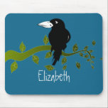 Customised Black Raven on a Tree Branch Mouse Pad<br><div class="desc">Image of a black crow / raven with a large white beak. Seems to be smiling about something. Sitting on a green tree branch with leaves attached and floating around. Blue background. Customise with a name in a handwritten scribble style font.</div>