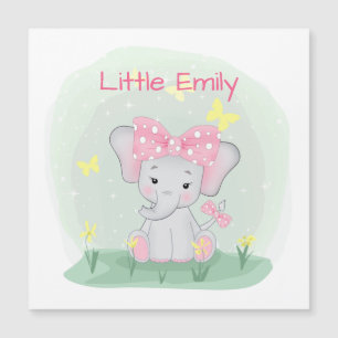 Cute baby elephant with a pink bow in a clearing
