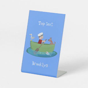 Cute boy sailor and dog rowing boat cartoon pedestal sign