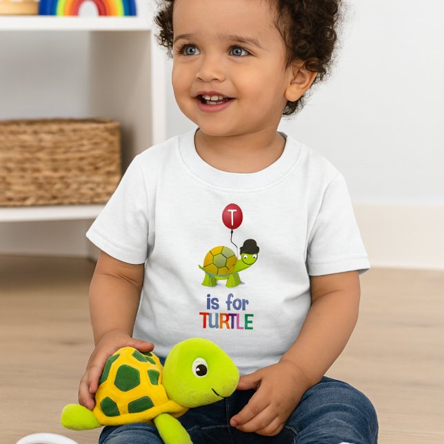 Cute Cartoon T is for Turtle Alphabet Baby T-Shirt (Happy toddler in turtle tee plays with plush toy bright, joyful room scene perfect for gifting.)