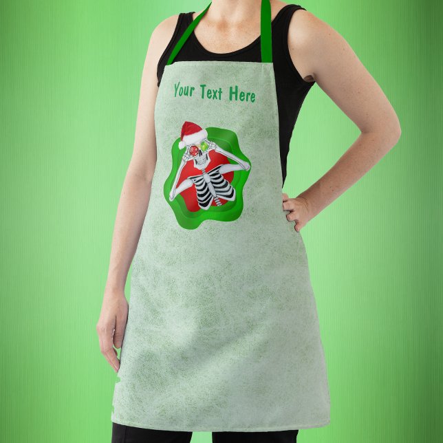 Cute Christmas skeleton Ornament Eyes in Splatter  Apron (Christmas skeleton in splatter shape holding ornaments to eyes on green kitchen apron.)