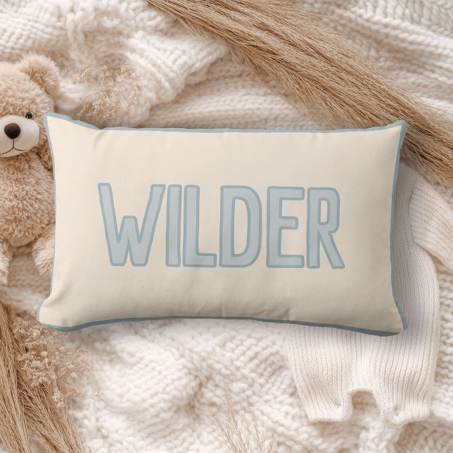 Cute Custom Kids Name with Faux Trim Lumbar Cushion (A cream pillow with "WILDER" in light blue lettering lies on a cozy, soft-knit blanket)