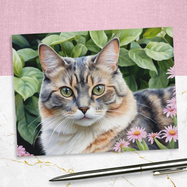 Cute Dilute Tortoiseshell Tortie Cat In Garden Postcard (A postcard of a cute dilute tortoiseshell cat, pictured in a garden with pink flowers)
