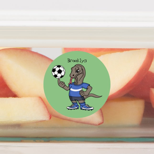 Cute funny Komodo dragon playing soccer cartoon (Affixed)