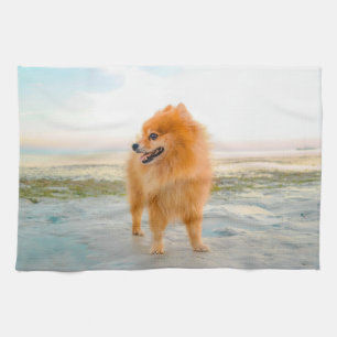 Cute Orange Pomeranian on Sandy Beach Tea Towel